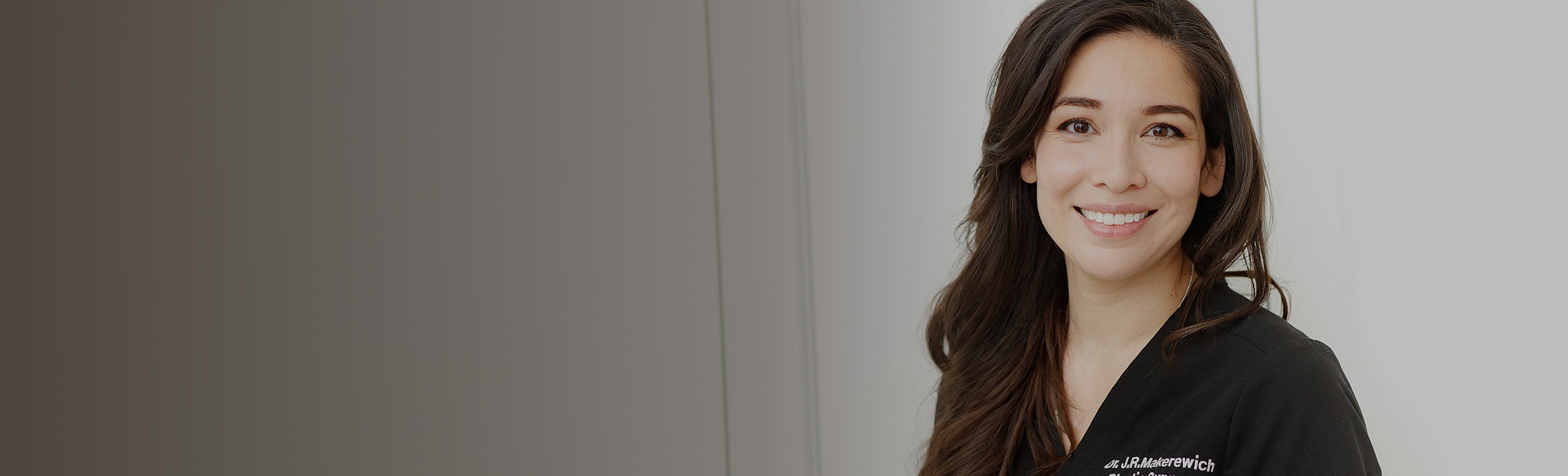 Smiling professional in medical attire.