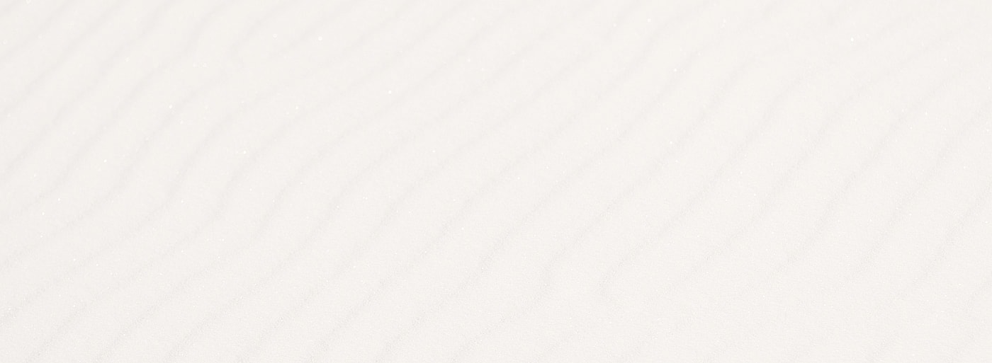 Rippling patterns in fine white sand.