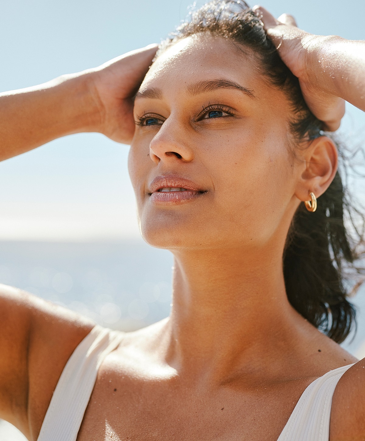 Woman enjoying sunlight by the beach.
