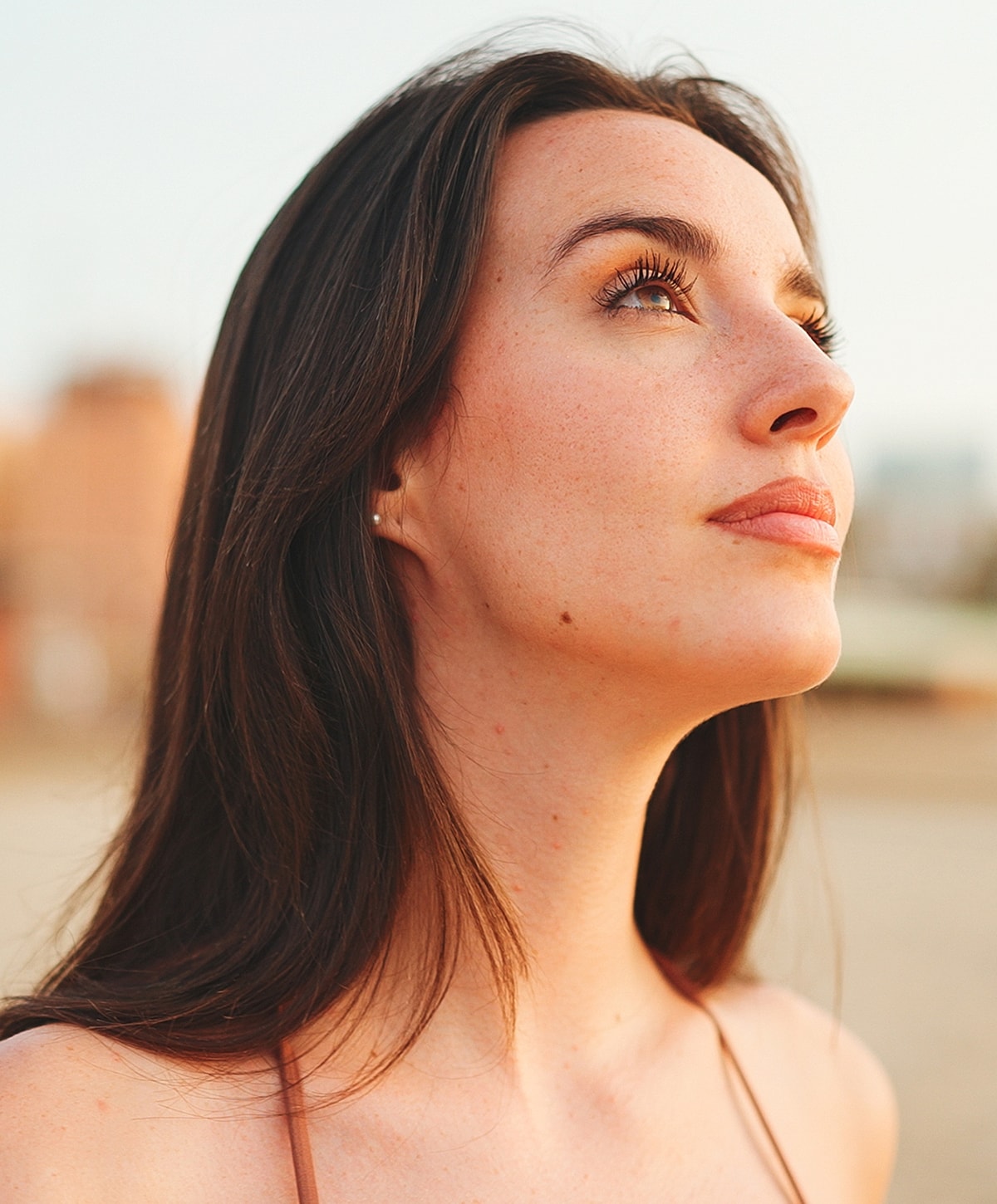 Woman looking upward with a soft expression.