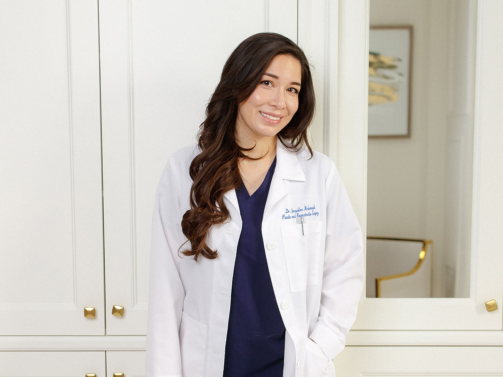 Dr. Rose in a white coat smiling indoors.
