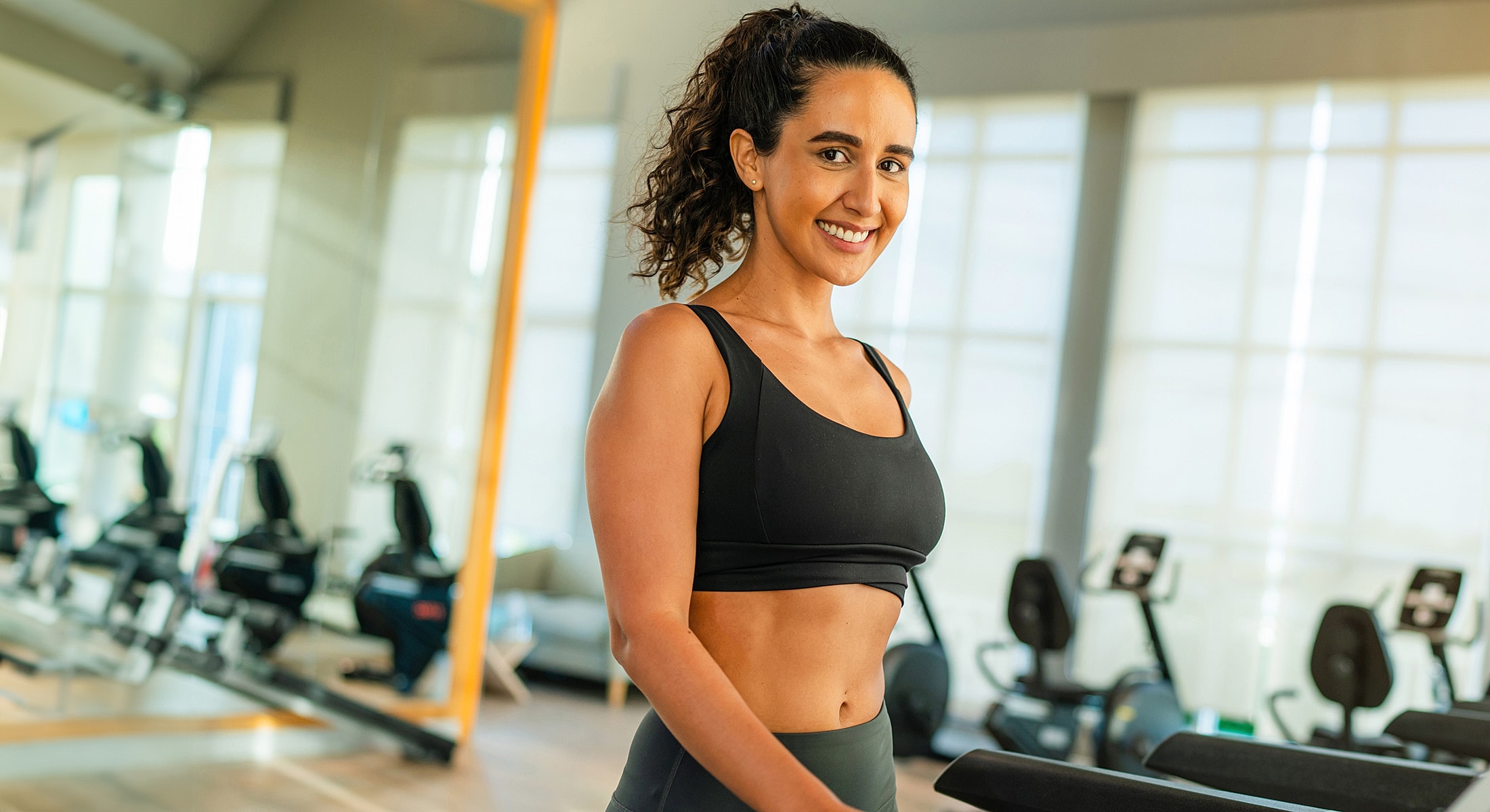 Smiling woman in gym attire at fitness center